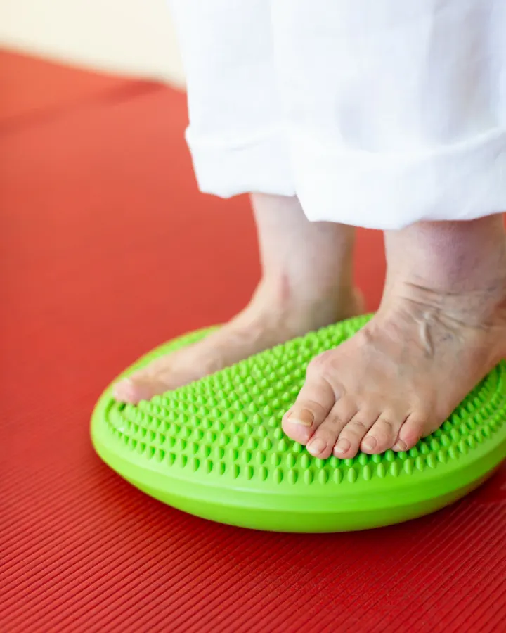Gleichgewichtsübung barfuß auf einem Balancekissen